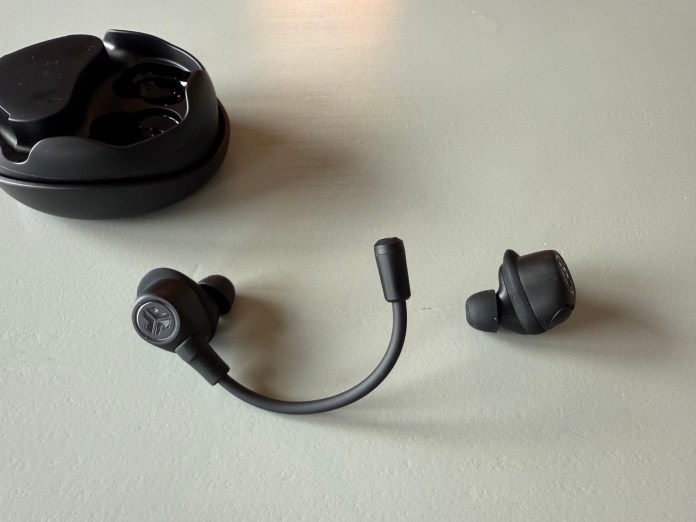 A pair of JLab Work Buds in-ear headsets with a removable microphone boom, displayed alongside their charging case on a plain surface.