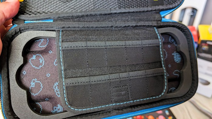 Interior view of the PowerA Pac-Man Protection Case for Nintendo Switch, showcasing the soft felt lining and storage compartments for game cards and accessories.