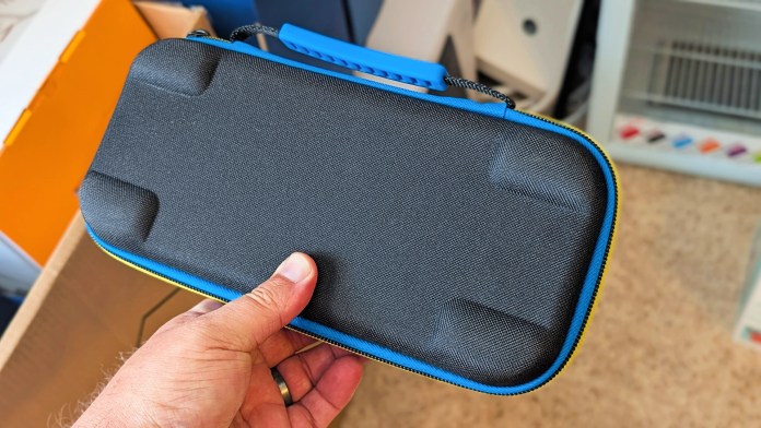 Top view of a black gaming case with blue and yellow accents, being held by a hand.