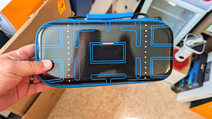 Hand holding a PowerA Pac-Man Protection Case for Nintendo Switch, featuring a colorful design reminiscent of the classic arcade game.