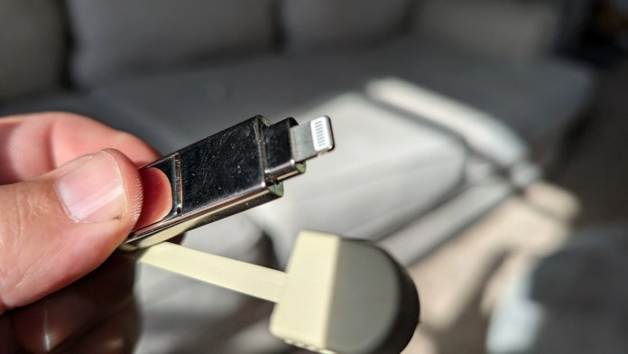 Close-up of a hand holding the Rolling Square inCharge XS Keyring Cable, showcasing its compact design and lightning connector.