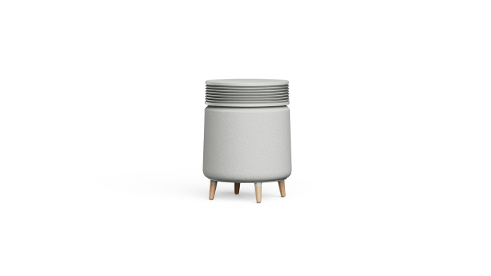 A compact, modern air purifier designed to blend with home decor, featuring a cylindrical shape and wooden legs.