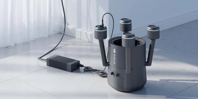 A robotic pool cleaner called BuHybrid L6, featuring a sleek design with multiple arms and a power cord attached, positioned on a tiled floor next to an electrical outlet.