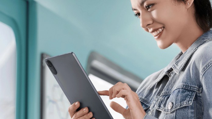 A young woman smiling while using a tablet, showcasing the Redmi Pad 2 in a casual setting.