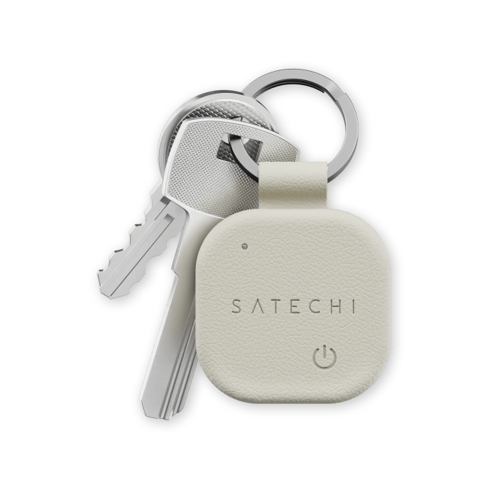 A Satechi FindAll Keychain attached to a set of keys, showcasing a smooth vegan leather design in a light color.