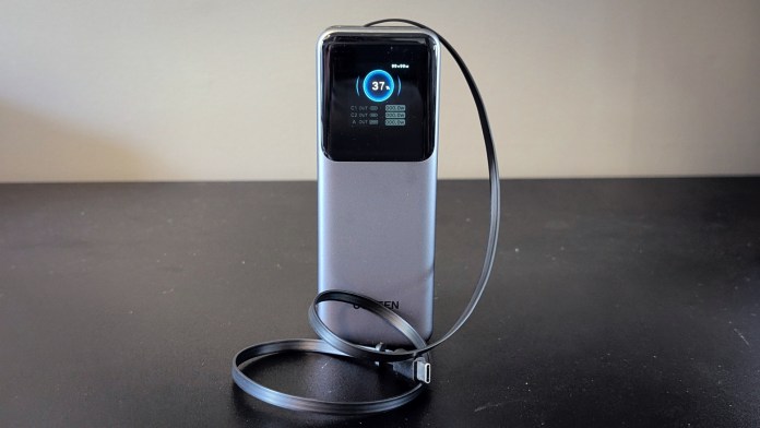 UGREEN Nexode Retractable Power Bank with a digital display and retractable cable, placed on a dark surface.