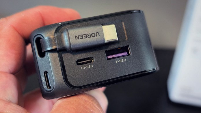 Close-up of the UGREEN Nexode Retractable 145W Car Charger showing the retractable USB-C and USB-A ports.