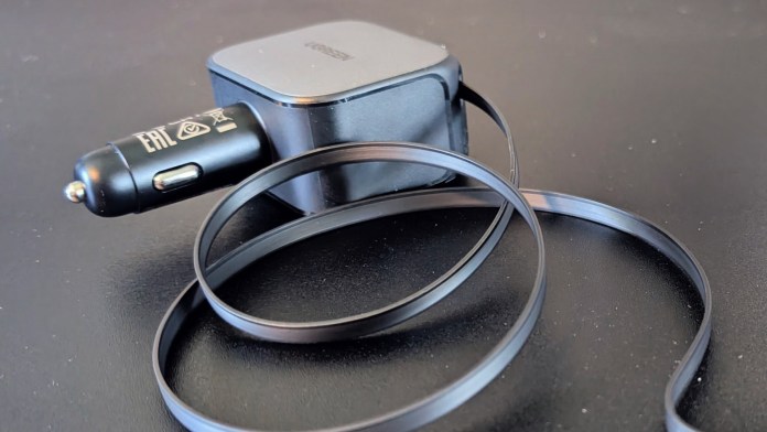 A UGREEN Nexode retractable car charger with a sleek design, featuring a retractable cable that helps reduce clutter. The device has a black color scheme and is positioned on a dark surface.