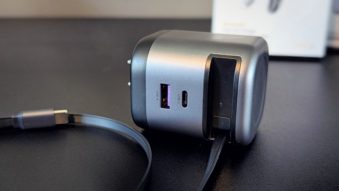 Close-up view of a UGREEN Nexode retractable car charger showing two USB ports and a retractable cable.
