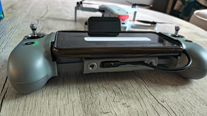 Close-up of the Potensic AT2-RC drone controller featuring a smartphone mounted on it, showcasing the design and control layout.