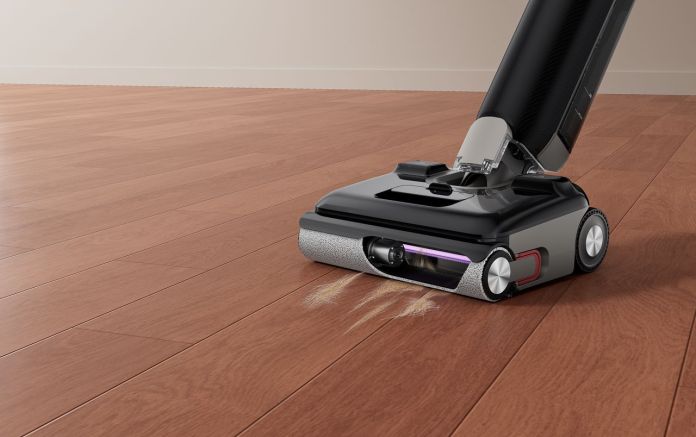 Close-up of the Eureka FloorShine 880 vacuum cleaner on wooden flooring, highlighting its cleaning brush and suction system.