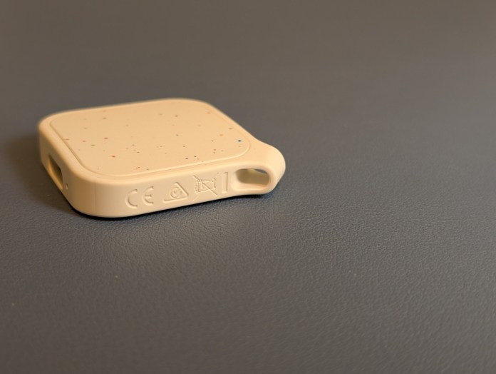Close-up view of the LOC8 Finder Fob 2 Universal tracking device on a gray surface.