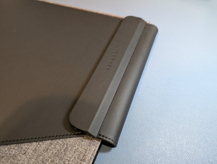 Close-up of the Journey Urban Laptop Sleeve showcasing a sleek design with a gray fabric and black leather cover, featuring a magnetic closure.