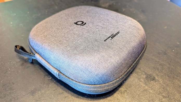 A gray soft-shell carrying case with a zipper, featuring a logo on the top, designed for protecting audio equipment.