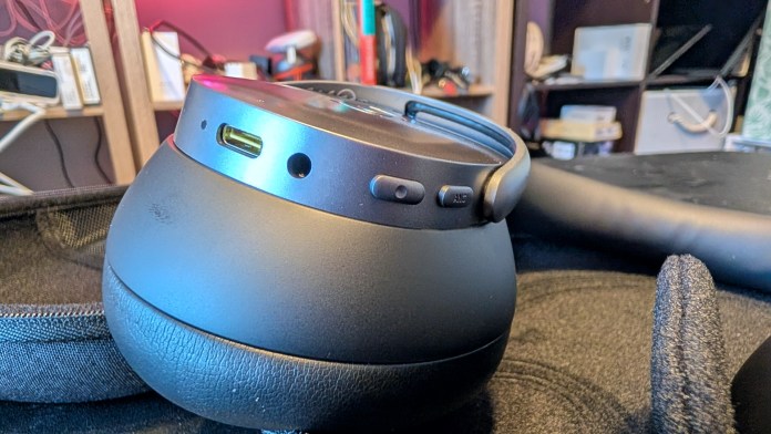 Close-up of the Baseus Inspire XH1 Noise-Canceling Headphones showcasing the charging port and buttons on the earcup.