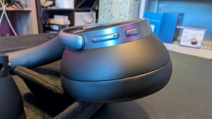 Close-up view of the ear cup of Baseus Inspire XH1 Noise-Cancelling Headphones, showing control buttons and soft padding.