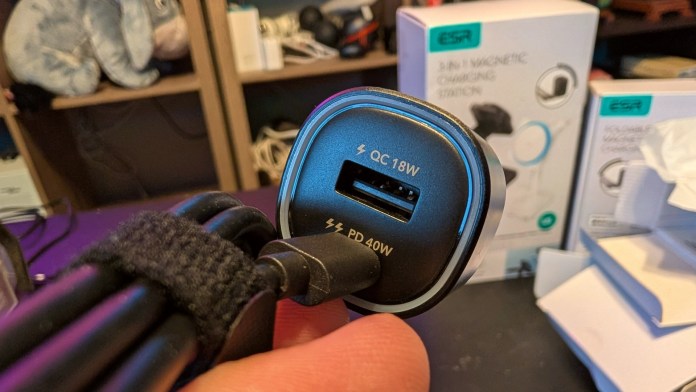 Close-up of the ESR CryoBoost 3-in-1 Magnetic Charging Station connector showing USB ports labeled QC 18W and PD 40W, with a blurred background featuring the charging station packaging.
