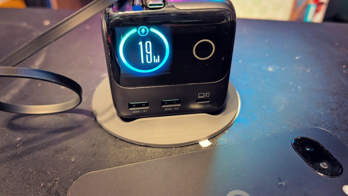 A black charging station with a digital display showing '19%' battery level, featuring multiple USB ports labeled for charging.