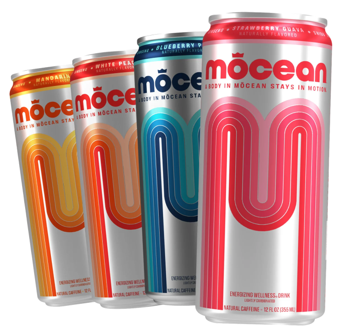 Four colorful cans of Mocean wellness drinks featuring flavors: Mandarin, White Peach, Blueberry Pomegranate, and Strawberry Guava.