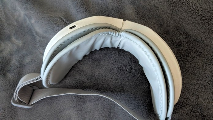 A pair of lightweight, grey headphones with a sleek design, set against a soft, dark background.