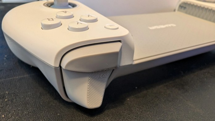 Close-up of a gaming controller with white buttons and a textured grip, showcasing the design details and functionality.