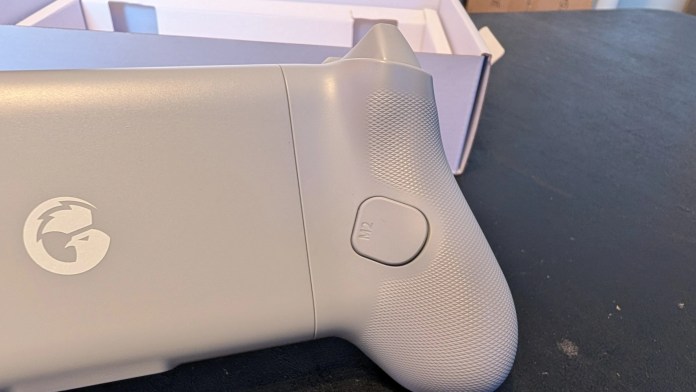 Close-up of a light gray game controller showing the logo and the M2 button.