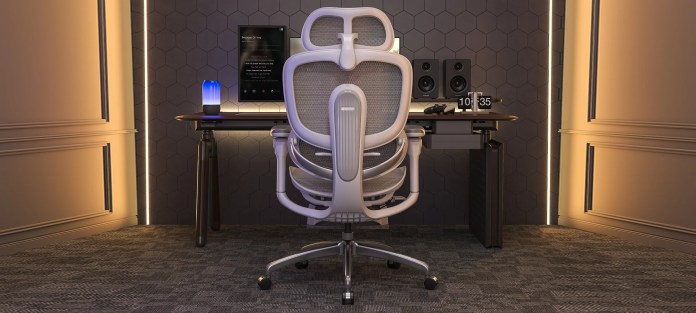 Modern home office setup featuring a sleek white ergonomic chair facing a computer desk with a blue lamp, speakers, and a digital clock on the desk, against a textured wall with ambient lighting.