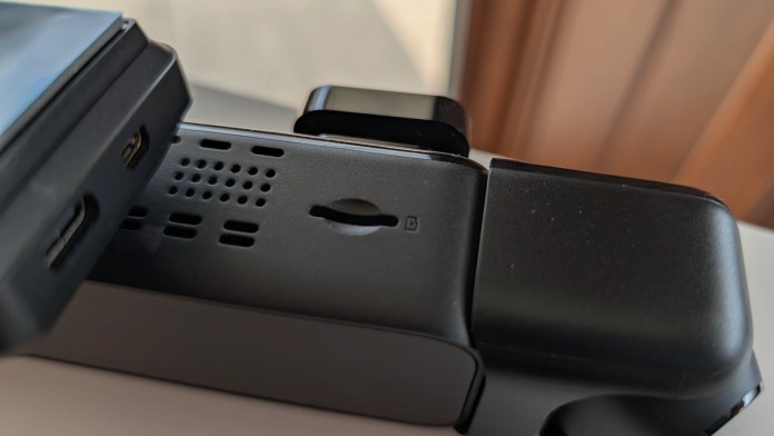 Close-up view of a gadget showing connectivity ports, speaker holes, and a secure latch mechanism.