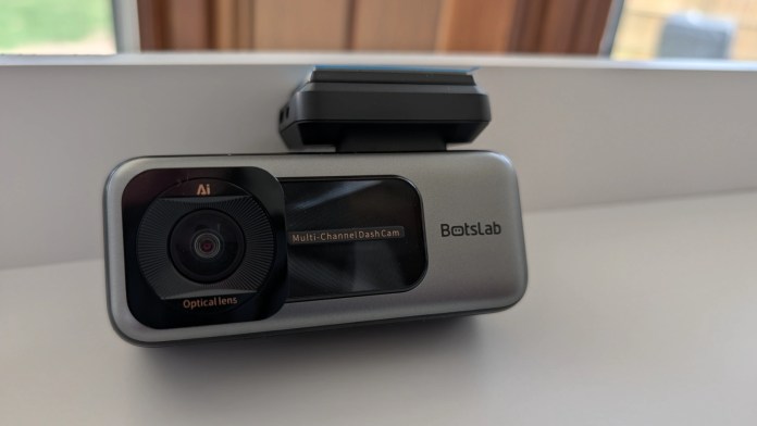 A BotsLab multi-channel dash camera featuring an optical lens and AI capabilities, placed on a light surface.
