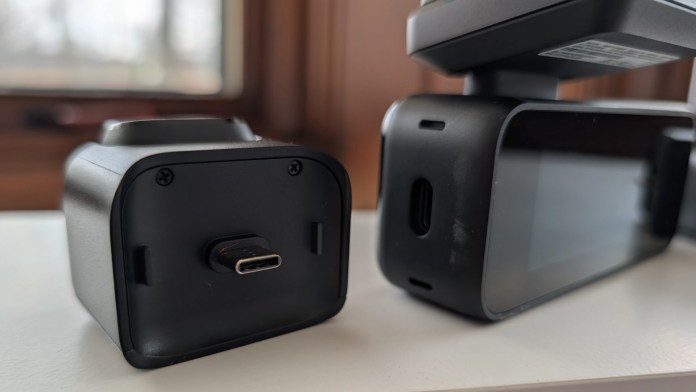 Close-up view of two electronic devices with USB-C ports, one with a screen and the other with a rounded top.