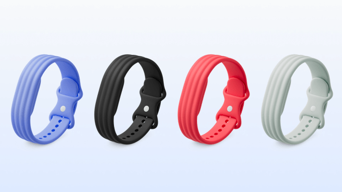 Four silicone wristbands in blue, black, red, and light gray, displayed against a soft gradient background.