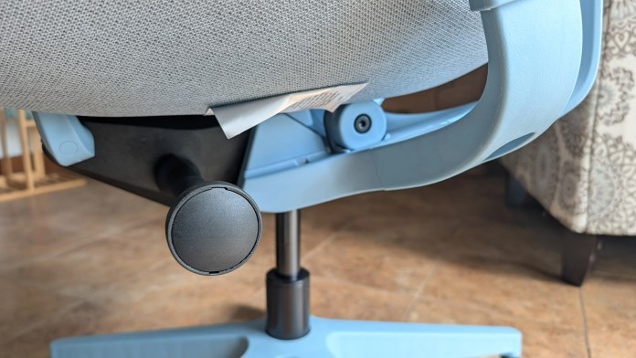 Close-up view of the adjustable mechanism of a blue office chair, showing the height adjustment lever and part of the seat.