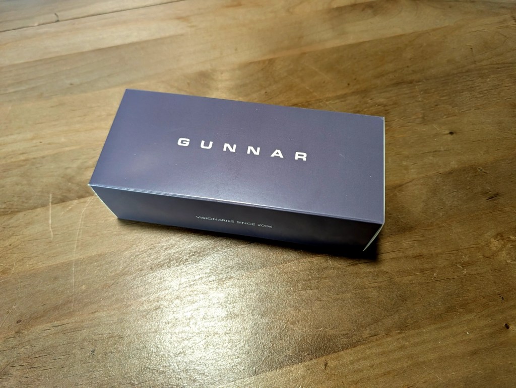 A closed box labeled 'GUNNAR' with the slogan 'VISIONARIES SINCE 2006' on a wooden surface.