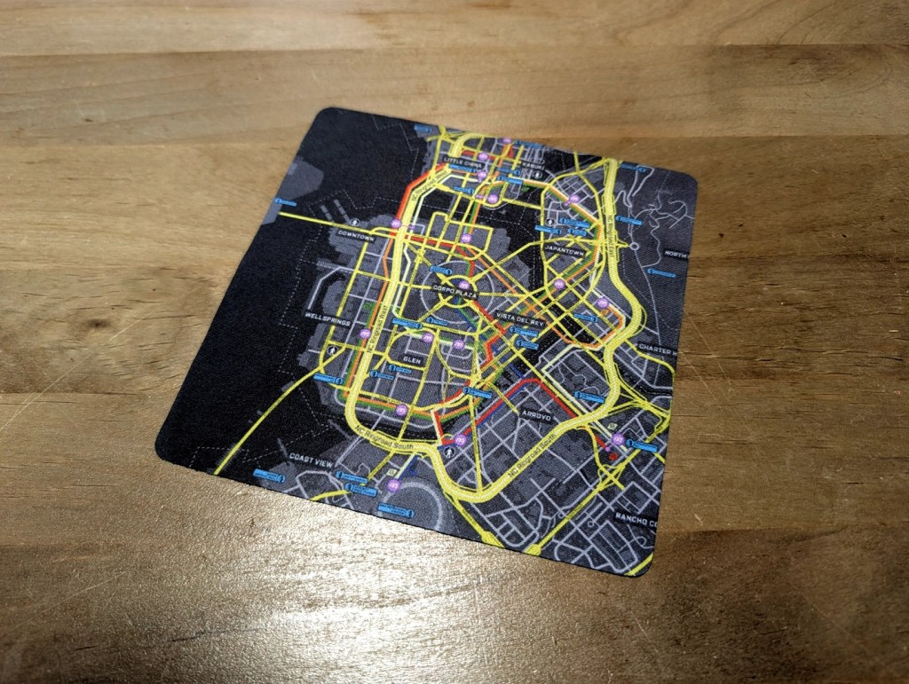 A close-up of a colorful city map featuring street and transportation lines, placed on a wooden surface.