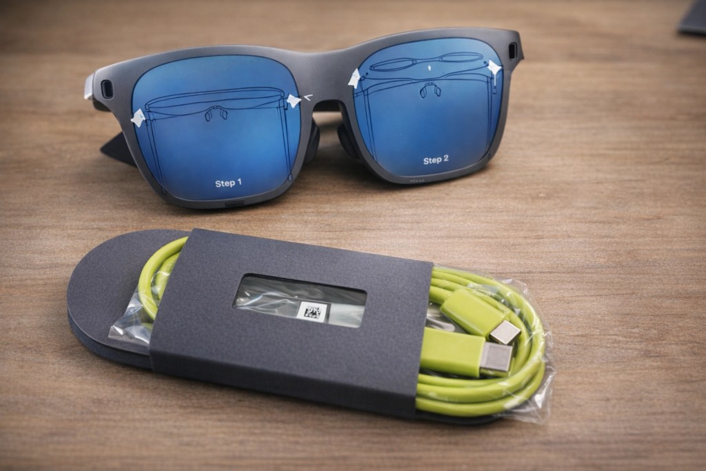 A pair of sunglasses with blue tinted lenses displaying instructional steps labeled 'Step 1' and 'Step 2', alongside a packaged green charging cable.